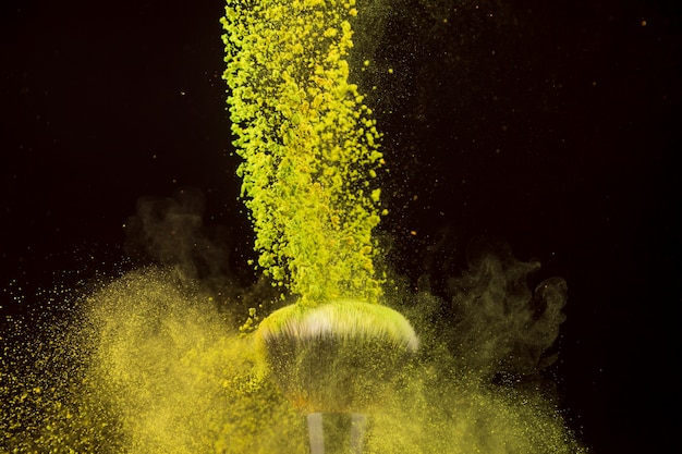 Color powder cascade falling on foundation brush