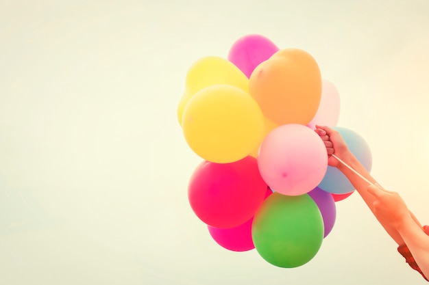 Free Photo colored balloons held by arms