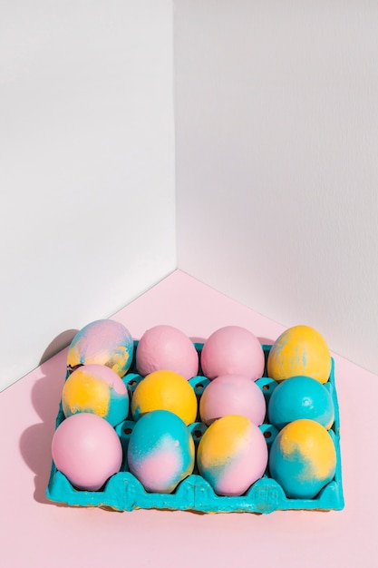 Free photo colored easter eggs in big bright rack on table