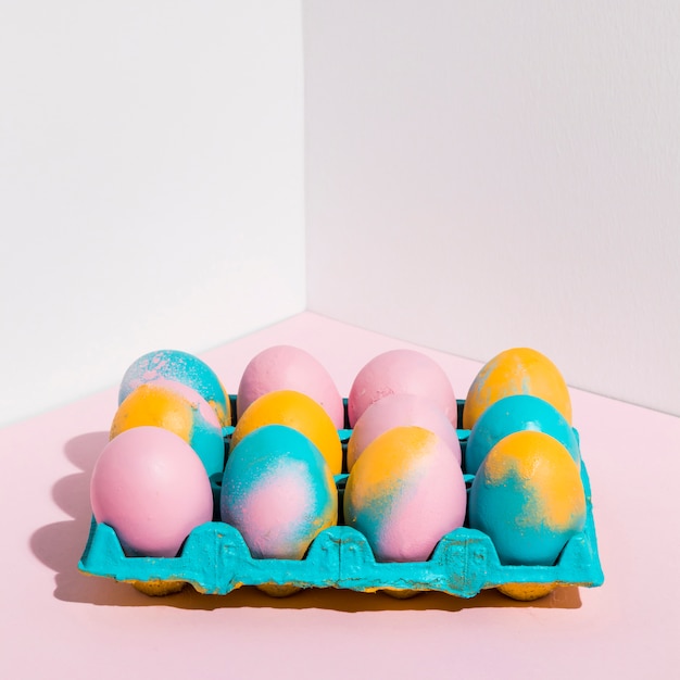 Free photo colored easter eggs in bright rack on table