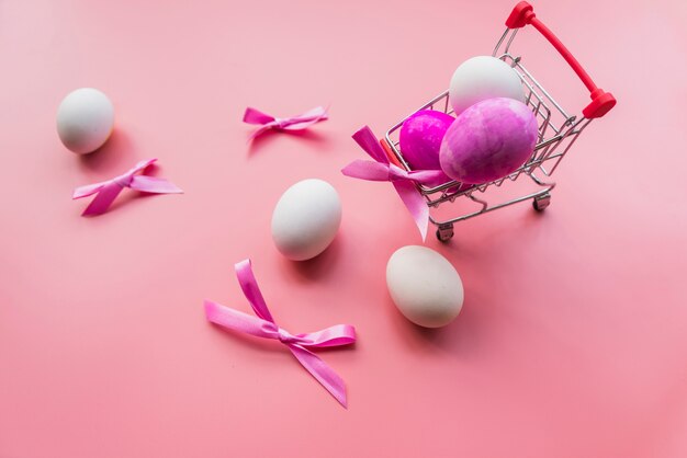 Colored eggs and bows in cart