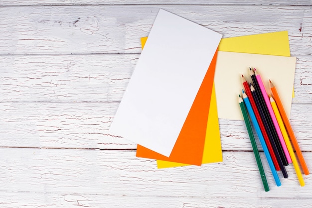 The colored pencils and papers stand on the table