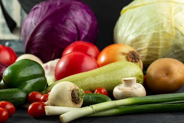 Colored vegetables fresh ripe salad vegetables such as green marrow and others on grey desk