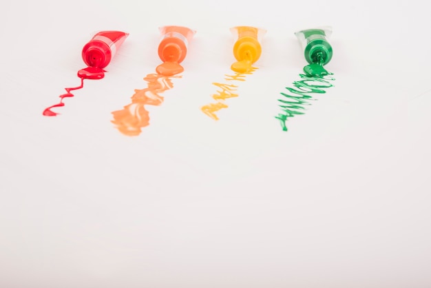 Free Photo colorful acrylic paints in tubes arranged in row over white background