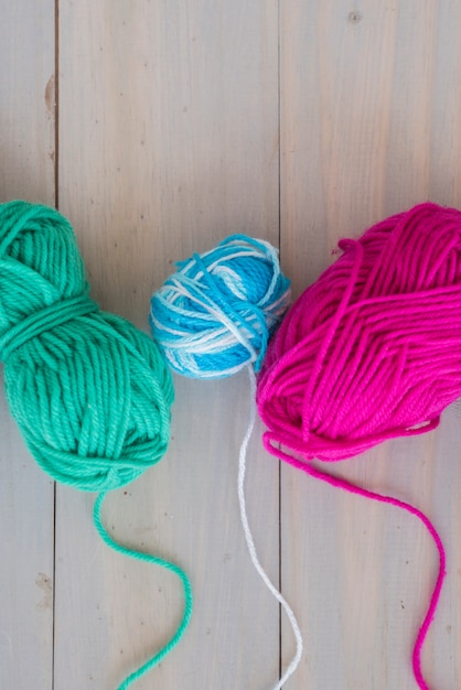 Free photo colorful ball of wool on wooden desk