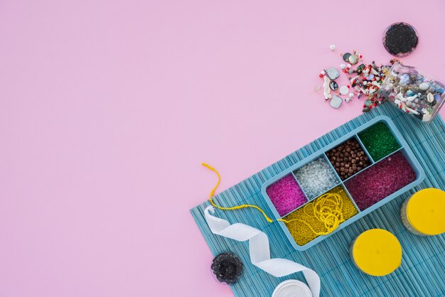 Colorful beads; ribbon and beads on pink backdrop