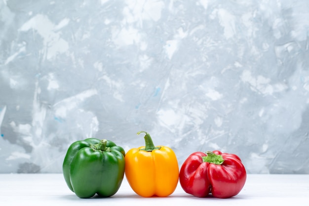 Free photo colorful bell-peppers lined on light