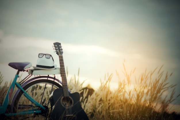 Free photo colorful of bicycle with guitar  in meadow