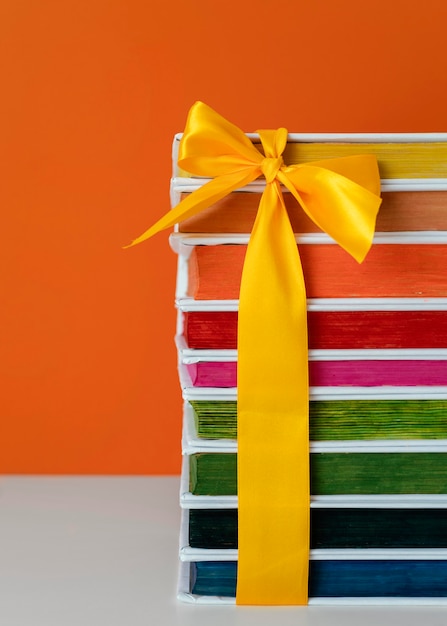 Free Photo colorful books stack with yellow ribbon