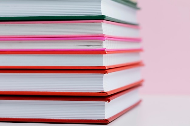 Colorful books with pink background close up