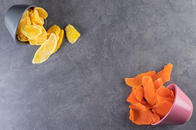 Colorful bowls of dried fruit pulps on stone table.