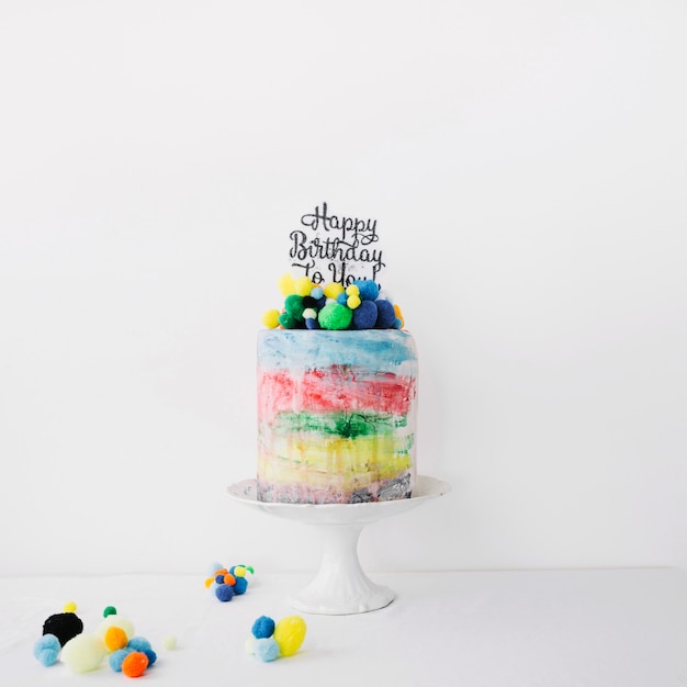 Free photo colorful cake decorated with stones and writing