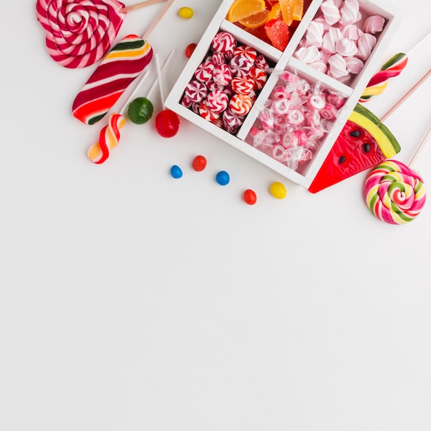 Free photo colorful candies on white table with copy space