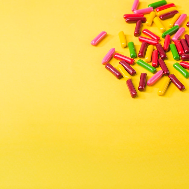 Free photo colorful candies on yellow background