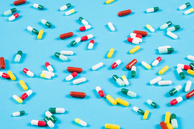 Free photo colorful capsules spread on blue background