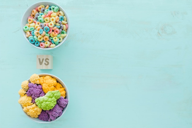 Free photo colorful cauliflower versus cereals in bowls over blue backdrop