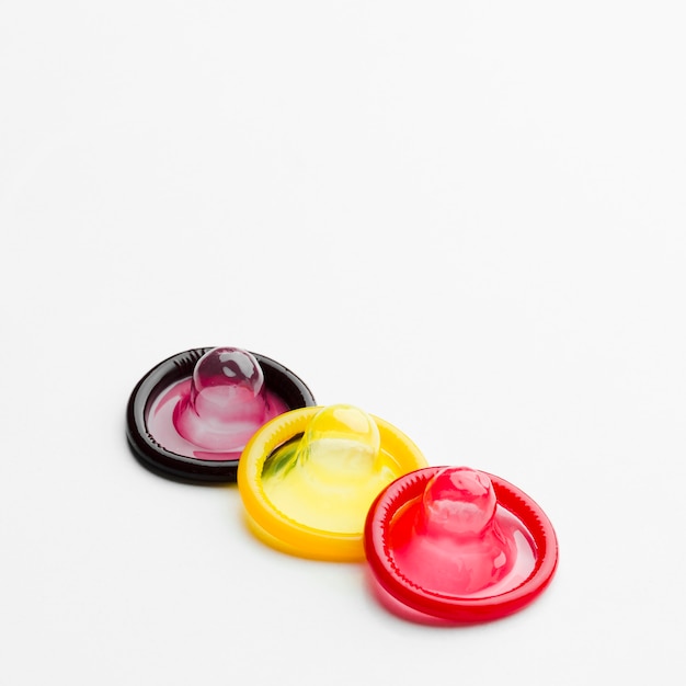 Colorful condoms on white background