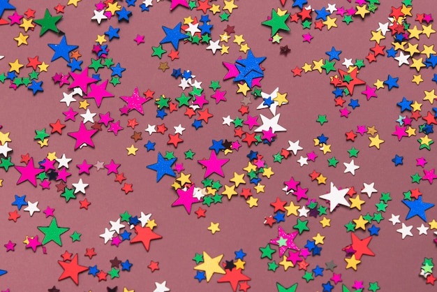 Free photo colorful confetti stars on purple background