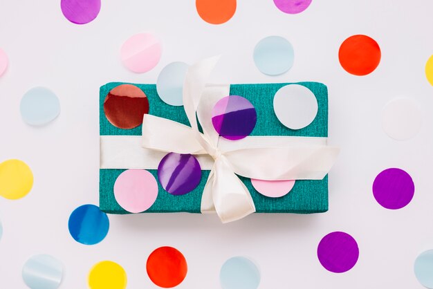 A colorful confetti over the wrapped gift box isolated on white background