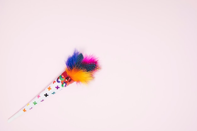 Free Photo colorful decorative feather cone against pink background