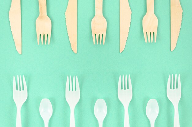 Colorful disposable cutlery on turquoise background