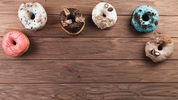 Colorful donuts on wooden background