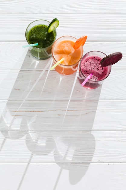 Colorful drinks in glasses on wooden table