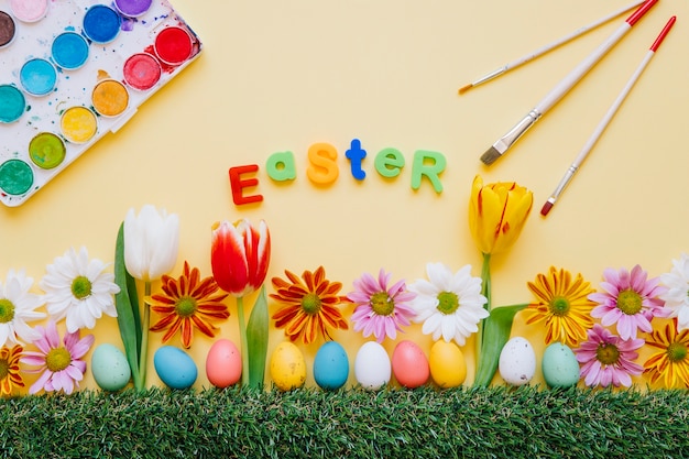 Colorful Easter arrangement with flowers and paints