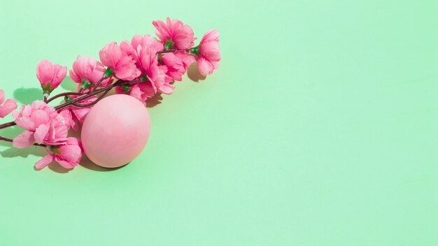 Colorful Easter egg with flowers on table