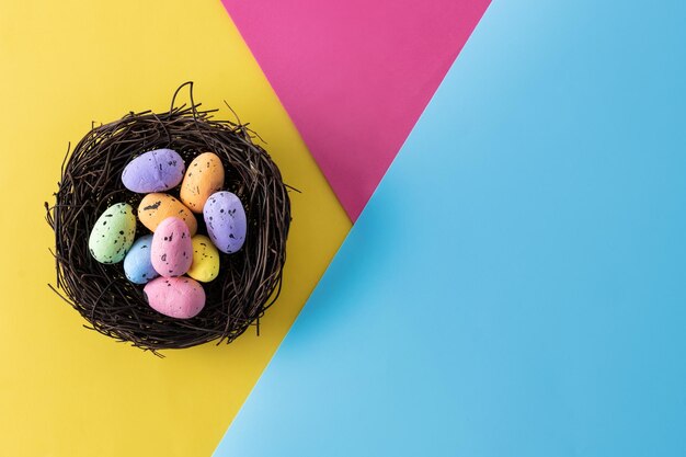 Colorful Easter eggs inside a nest on colorful background