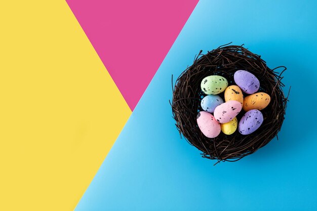 Colorful Easter eggs inside a nest on colorful background