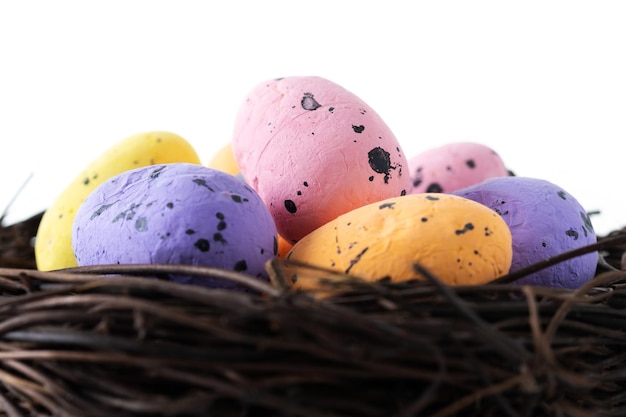 Free photo colorful easter eggs inside a nest isolated on white background