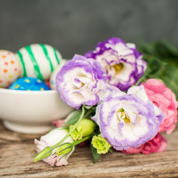 Colorful easter eggs and lisianthus on wooden table