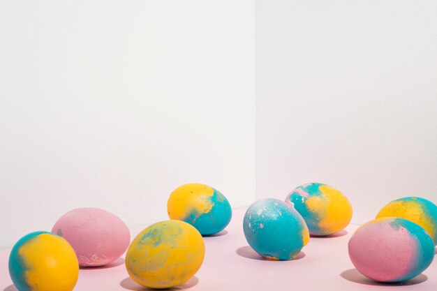 Free photo colorful easter eggs scattered on light table