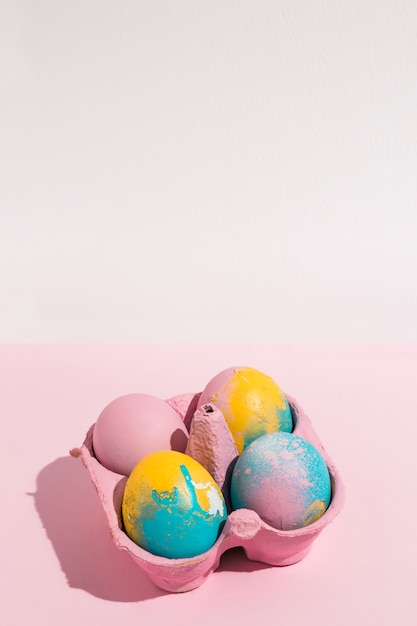 Free photo colorful easter eggs in small rack on pink able