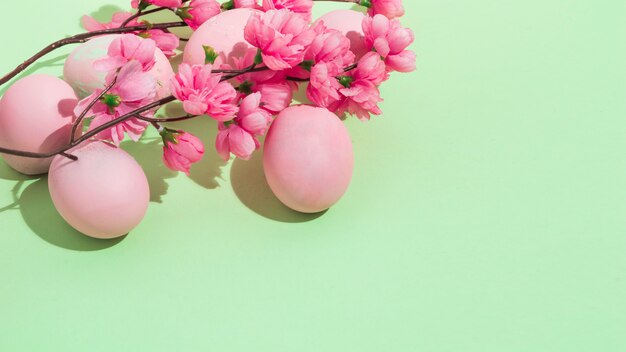 Colorful Easter eggs with flowers on green table