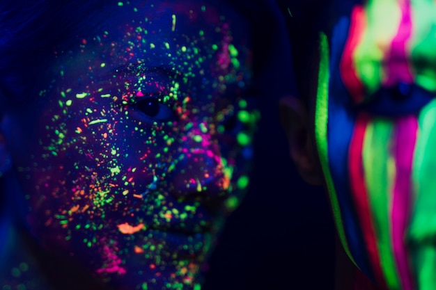 Free photo colorful fluorescent make-up on woman and man face