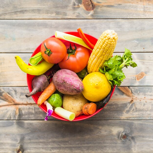 Colorful fresh vegetables in bowl on wooden tabletop