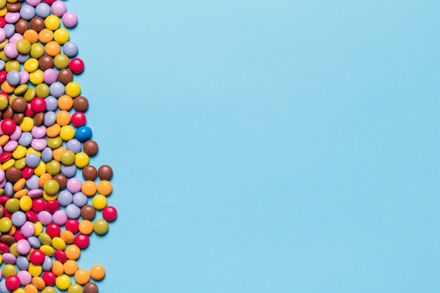 Free photo colorful gem candies on the side of blue background