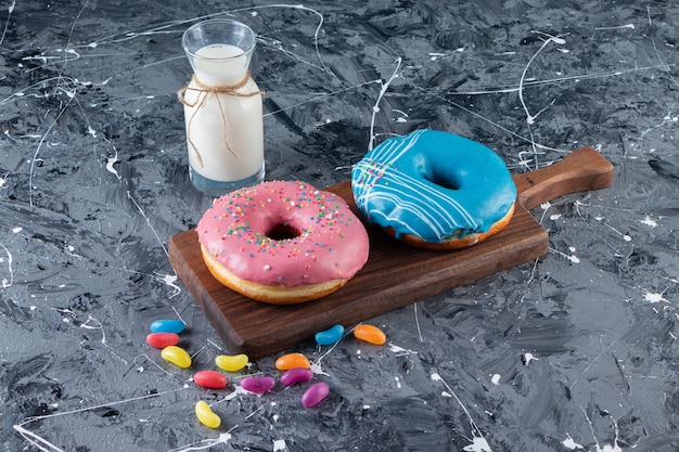 Free photo colorful glazed doughnuts on a marble table.