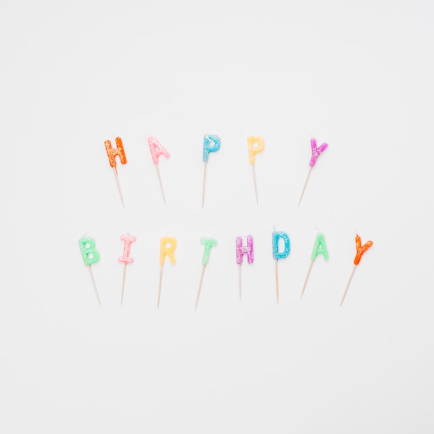 Free photo colorful happy birthday lettering candles on white background