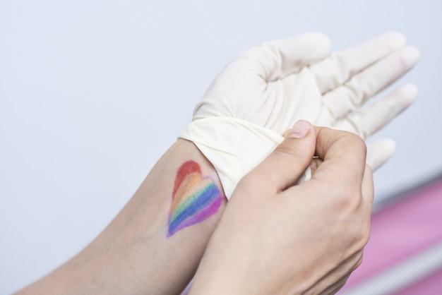 Free photo colorful heart-shaped pride flag on a person's hand