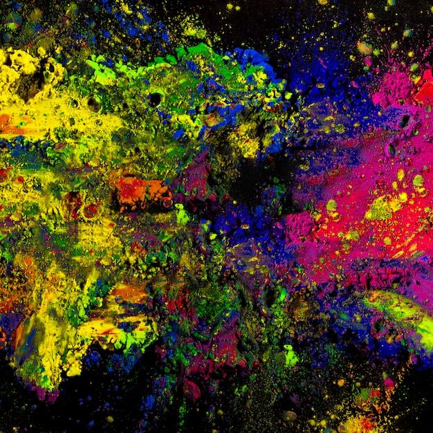 Colorful holi powder splatted on black backdrop