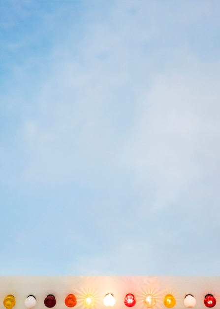 Colorful illuminated light bulbs against blue sky