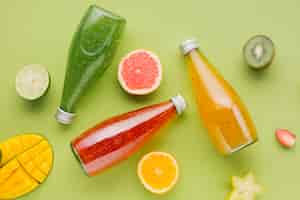 Free photo colorful juice bottles and fruit slices