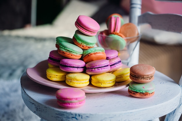 Colorful macaroons lie on pink plate 