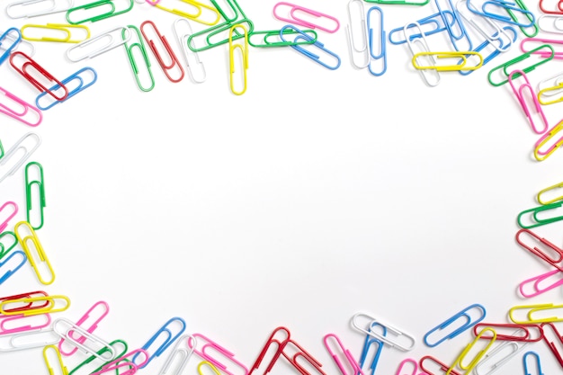 Colorful paper clips isolated on white with free space in the centre.