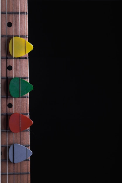 Colorful picks on neck of guitar