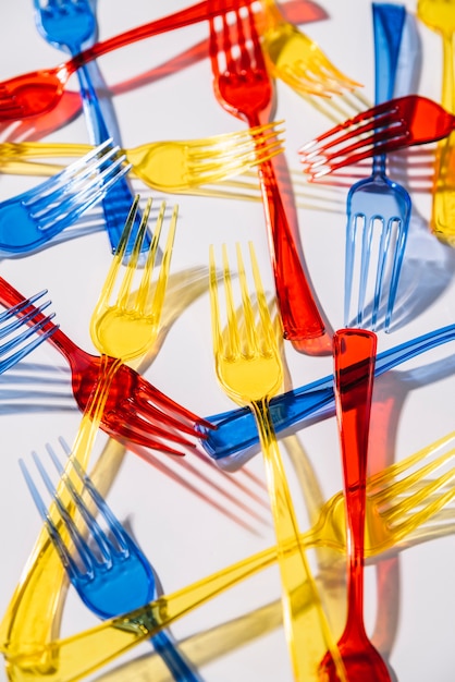 Free photo colorful plastic forks on white background