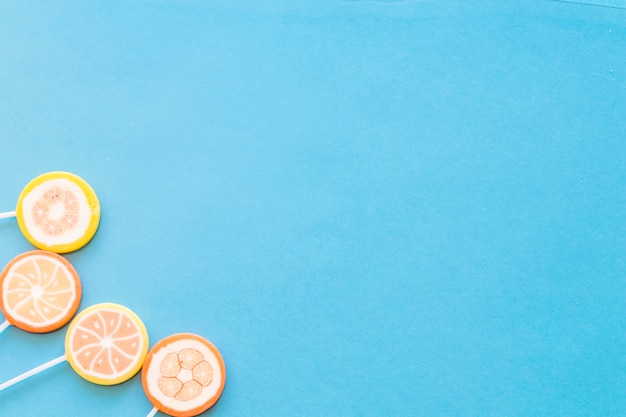 Free photo colorful round lollipop candies on blue background